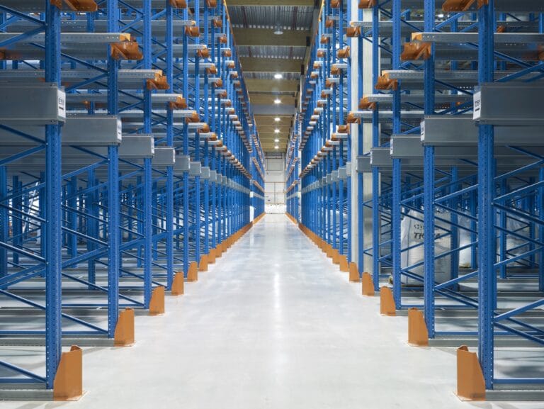Empty warehouse with blue metal shelving units.