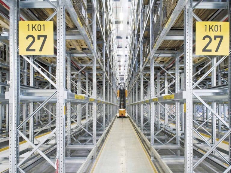 Warehouse aisle with metal shelving and signs