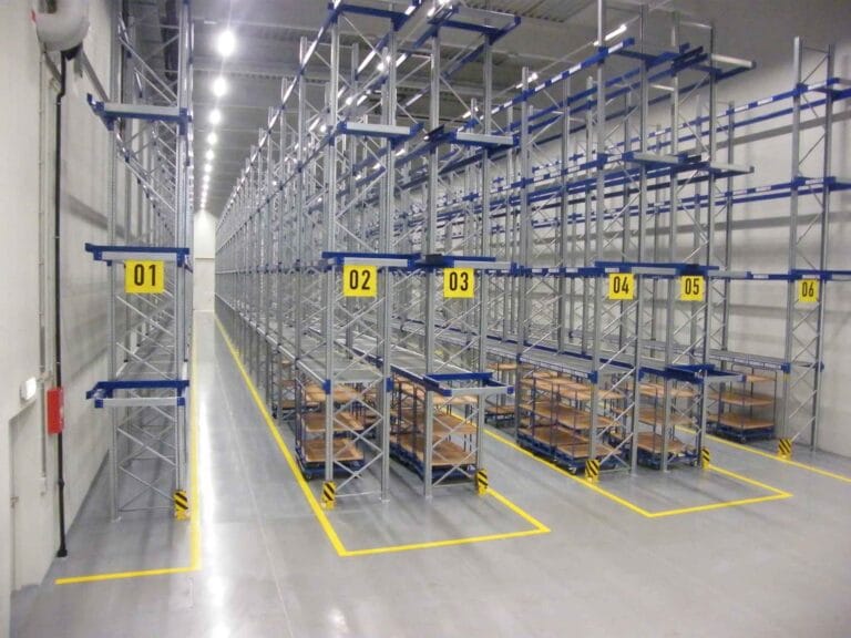 Empty warehouse racking system with numbered sections.