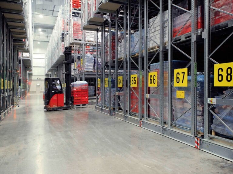 Forklift navigating warehouse with numbered shelves.