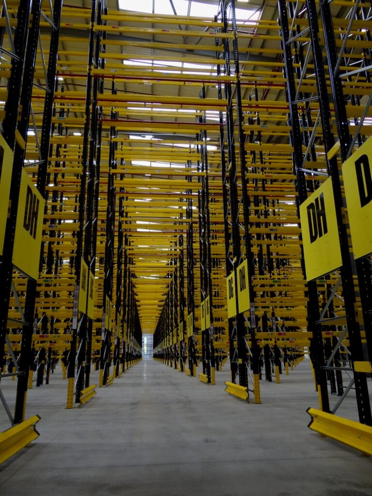 Empty warehouse shelves with yellow beams.